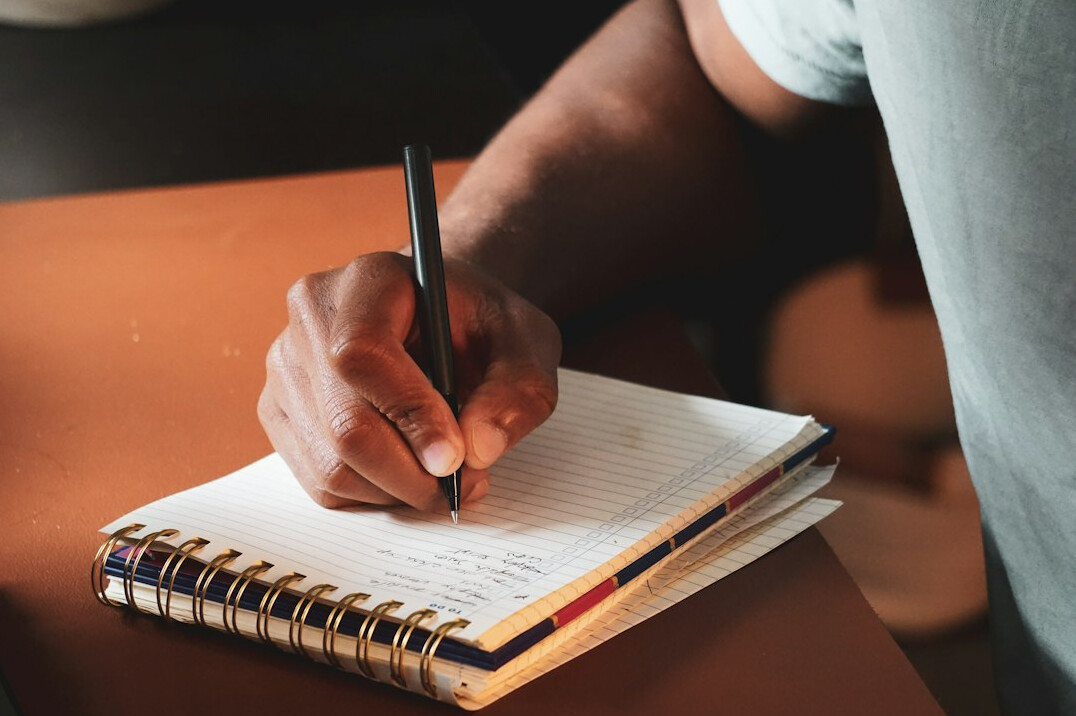 person writing in gratitude journal
