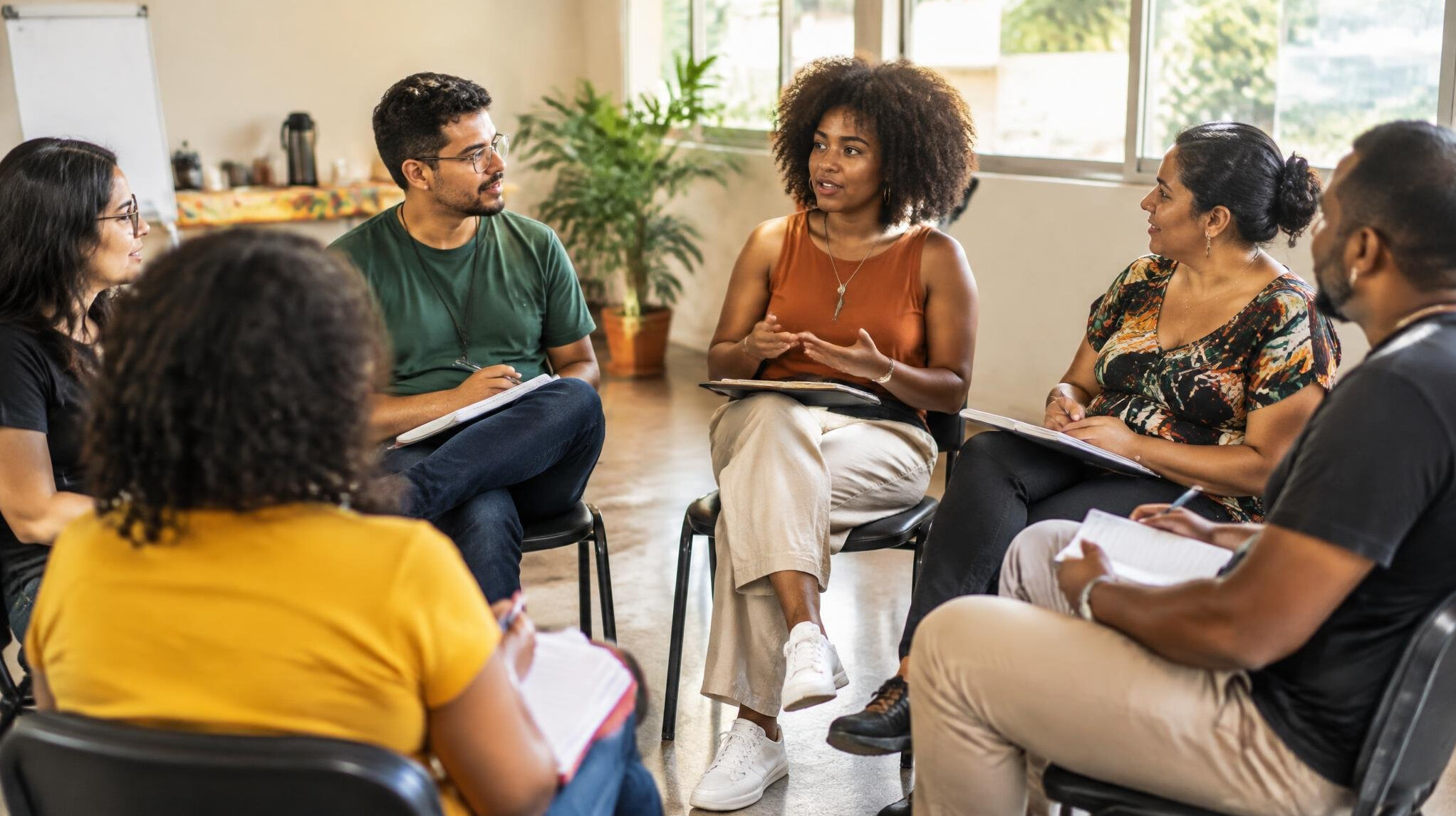 Group of people sitting in a circle discussing during a workshop