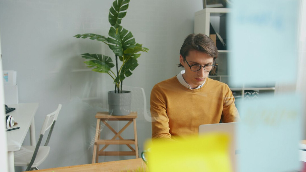 man writing notes in office